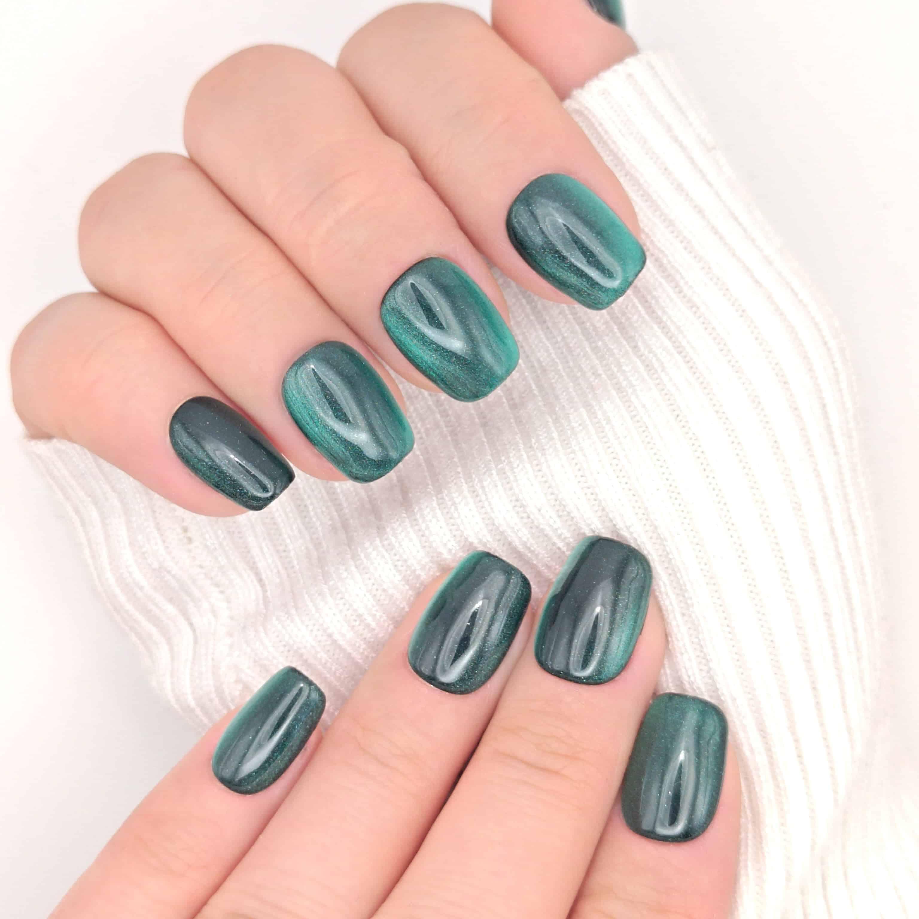 Mani con press on nails verde foresta occhio di gatto corte