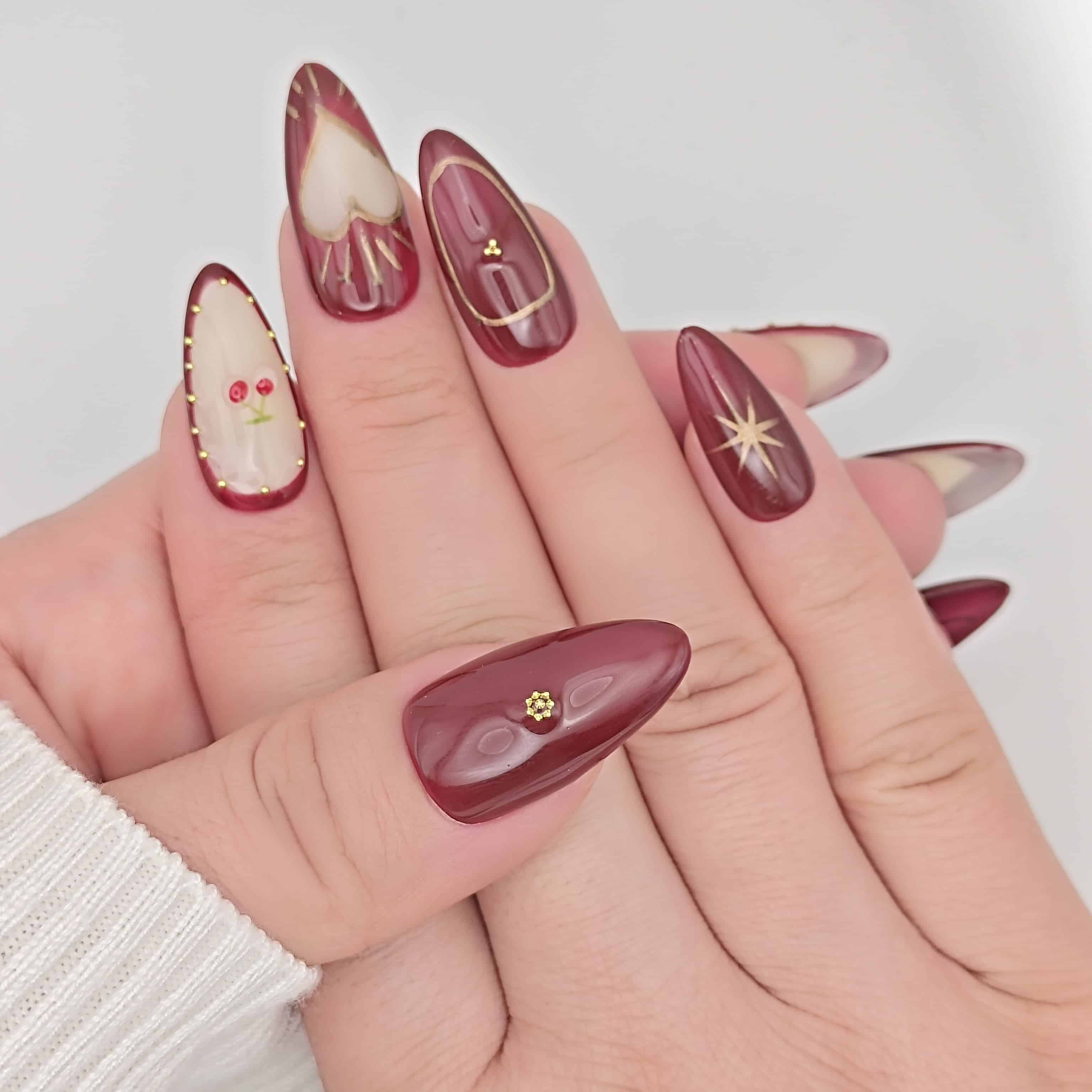 Unghie press on mandorla lunga amarena rosso con disegno ciliegia e dettagli oro